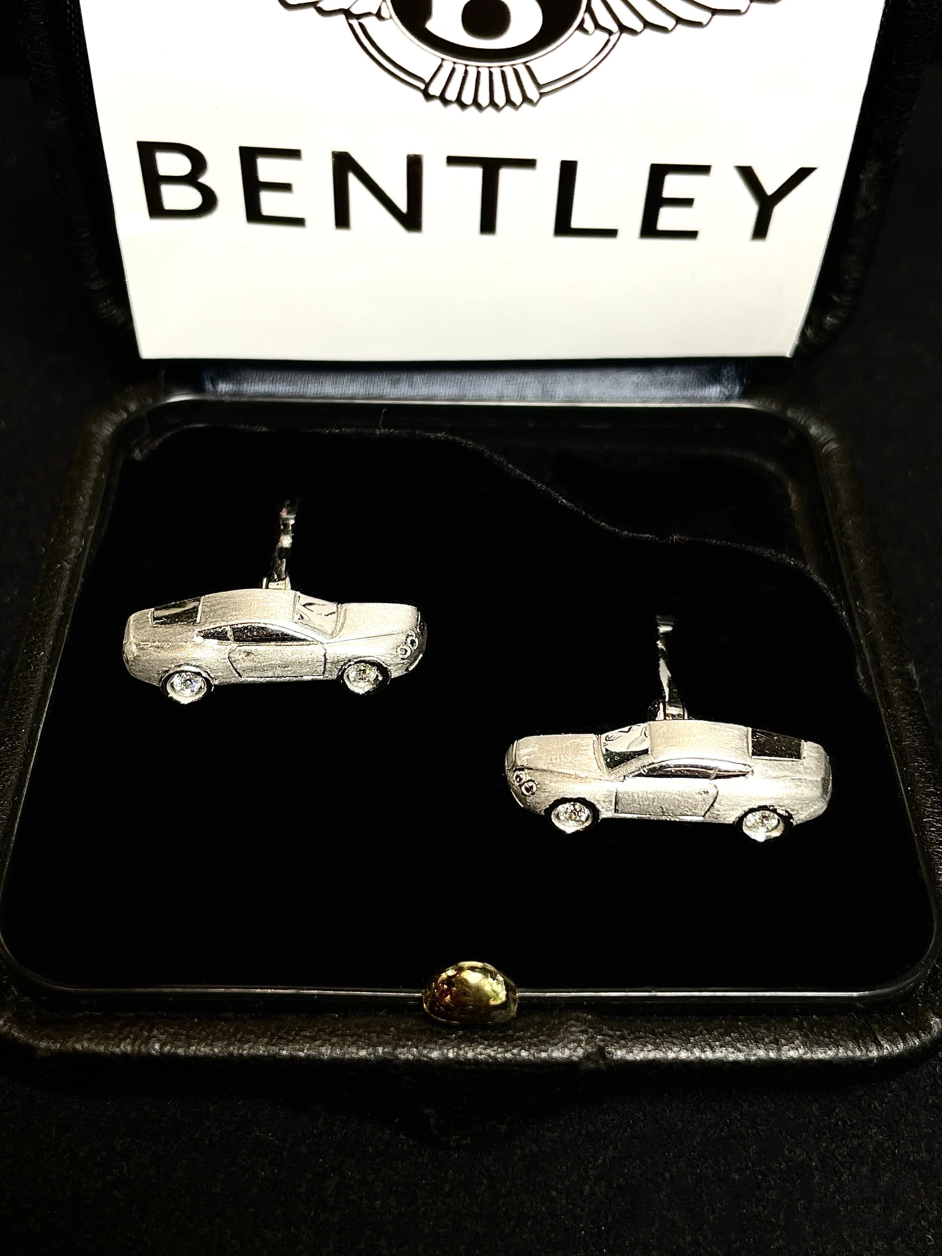Pair of Bentley-inspired 18K white gold cufflinks shaped as classic sports cars with diamond-set wheels, presented in a luxury gift box for collectors and automotive enthusiasts.