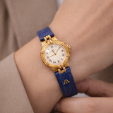 Maurice Lacroix Damen Uhr Gold mit blauem Lederarmband am Handgelenk