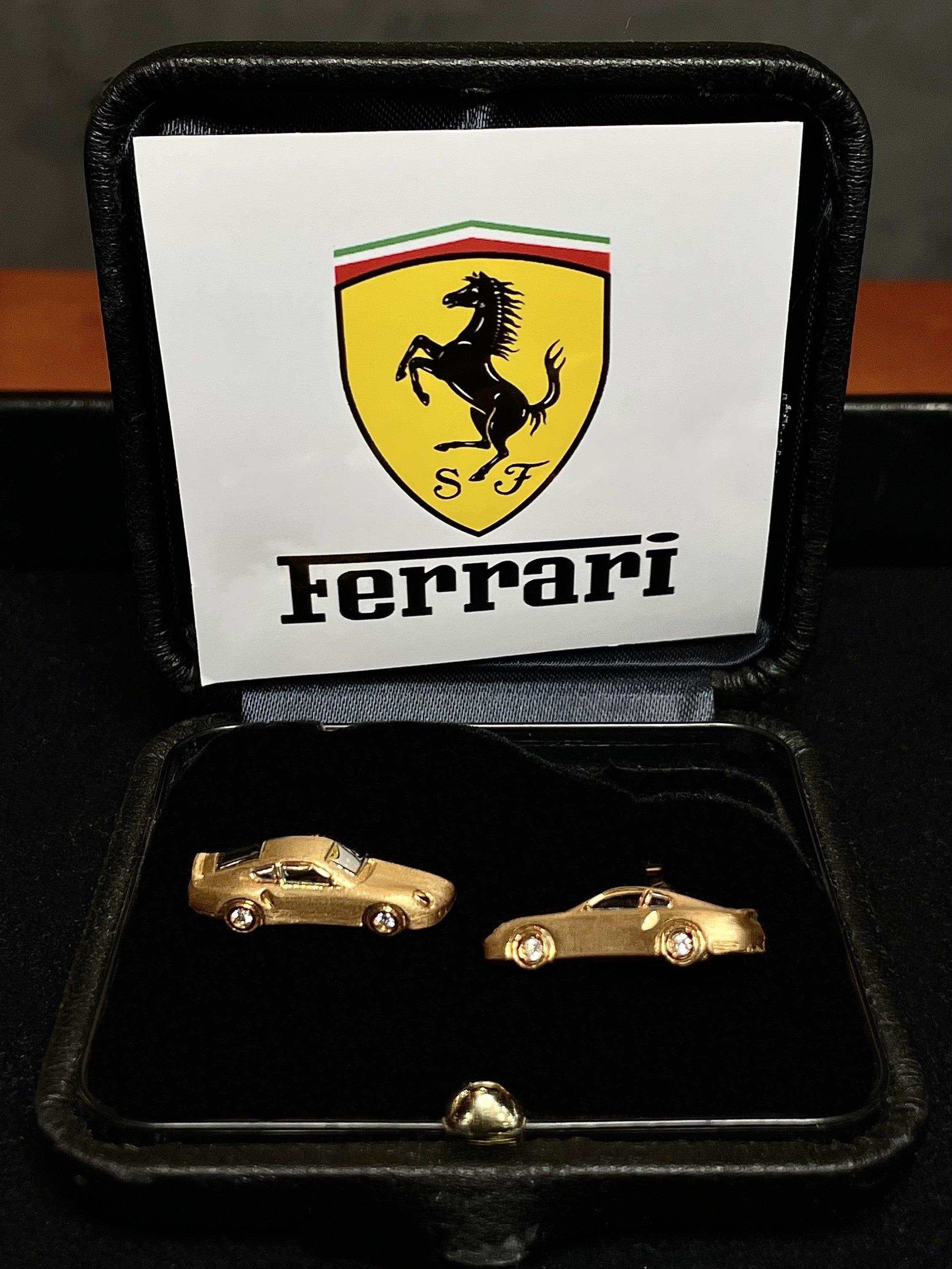 Pair of Ferrari Retro-inspired 18K yellow gold cufflinks featuring detailed classic sports car designs with brilliant-cut diamond wheels, presented in a luxury gift box for collectors and automotive enthusiasts.